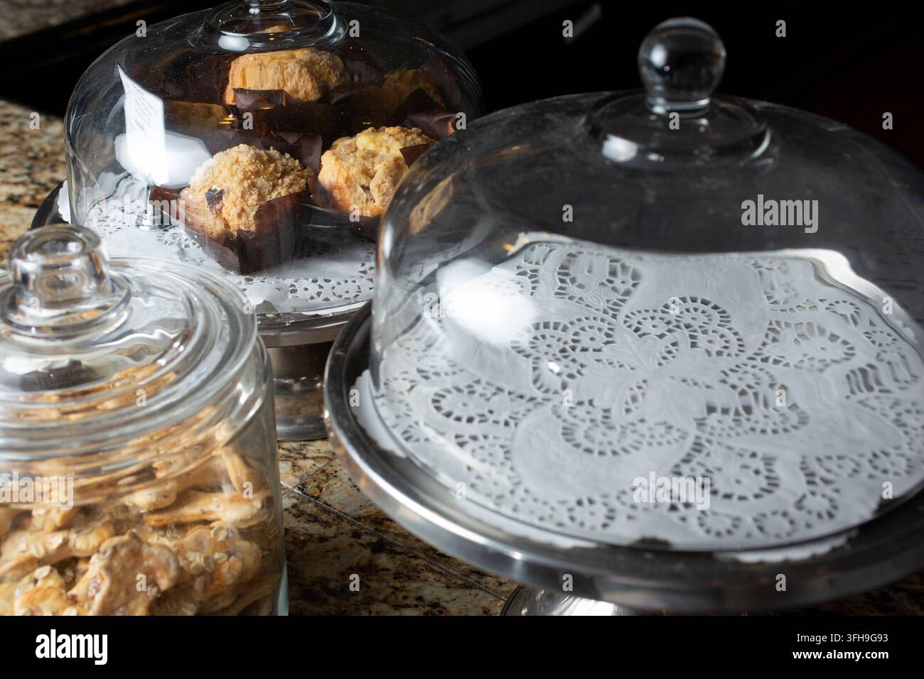 Una vista di alcune vetrine di vetro con pasticcini e torte, visti in una panetteria locale. Foto Stock