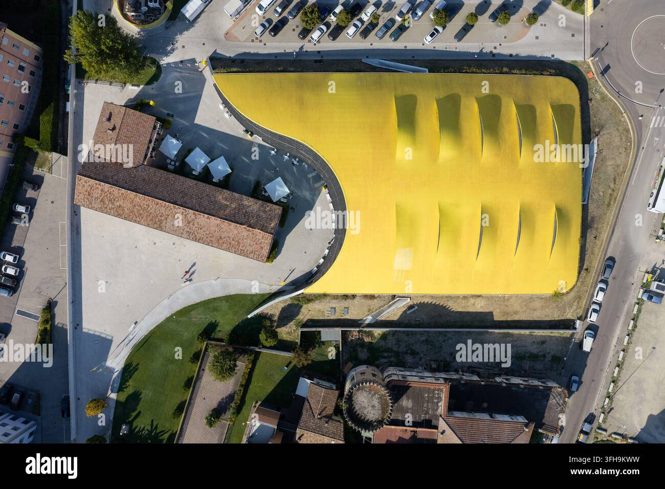 Vista aerea del Museo Enzo Ferrari con il suo iconico tetto giallo e l'edificio storico adiacente a Modena, Emilia-Romagna, Italia. Foto Stock