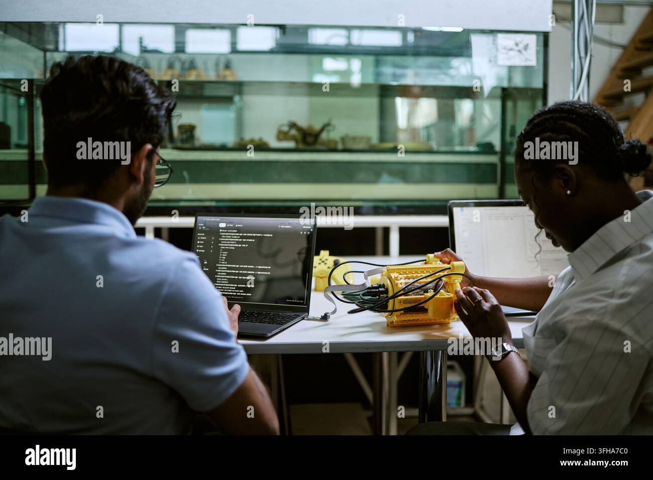 Diversi ingegneri che codificano e testano la robotica subacquea in laboratorio Foto Stock
