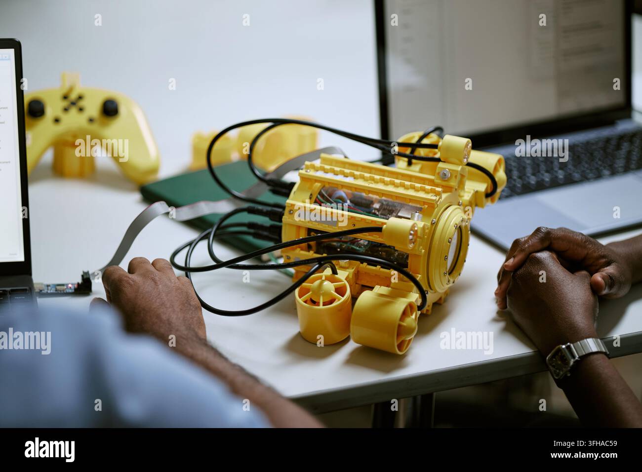 Ingegneri neri che sviluppano un prototipo di robot subacqueo con laptop Foto Stock