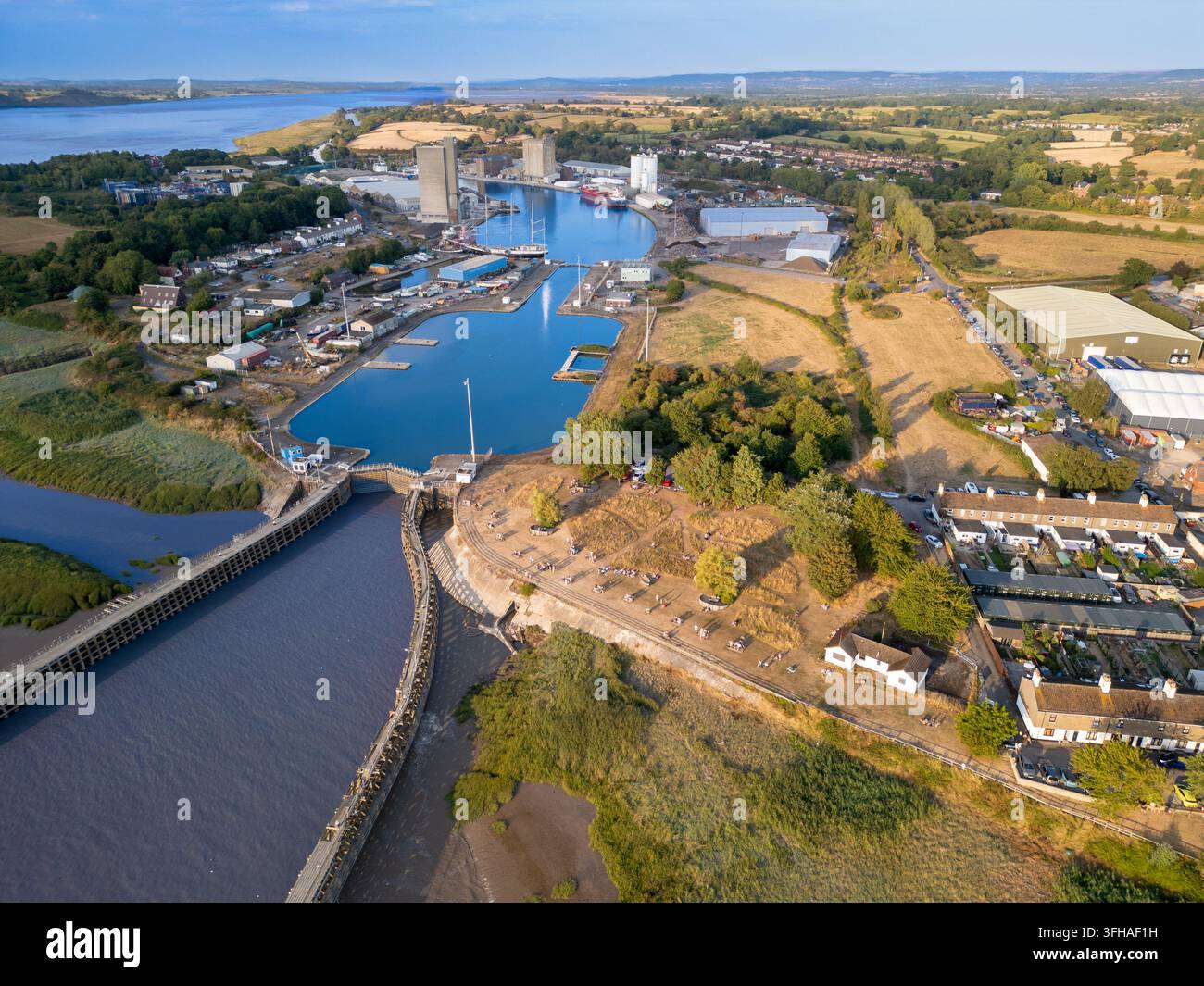 Vista aerea dei Sharpness Docks e del canale Gloucester e Sharpness con edifici industriali, campi verdi e l'estuario del fiume Severn Foto Stock