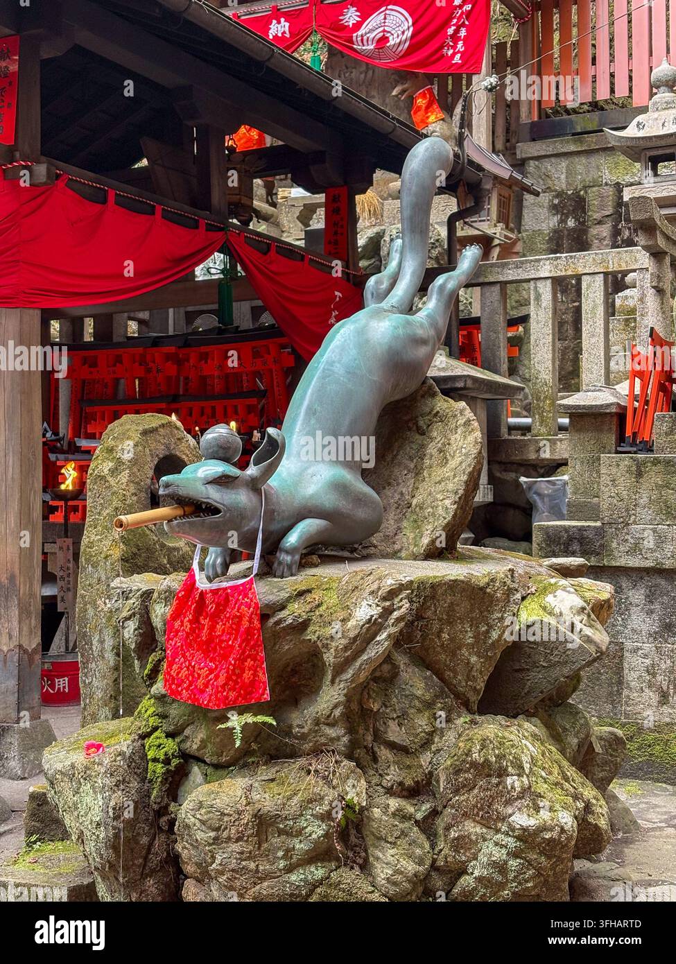 Statua dinamica in bronzo di un kitsune volpe che tiene un rotolo nella bocca al Fushimi Inari Taisha a Kyoto, Giappone. - Immagine stock catturata con smartphone