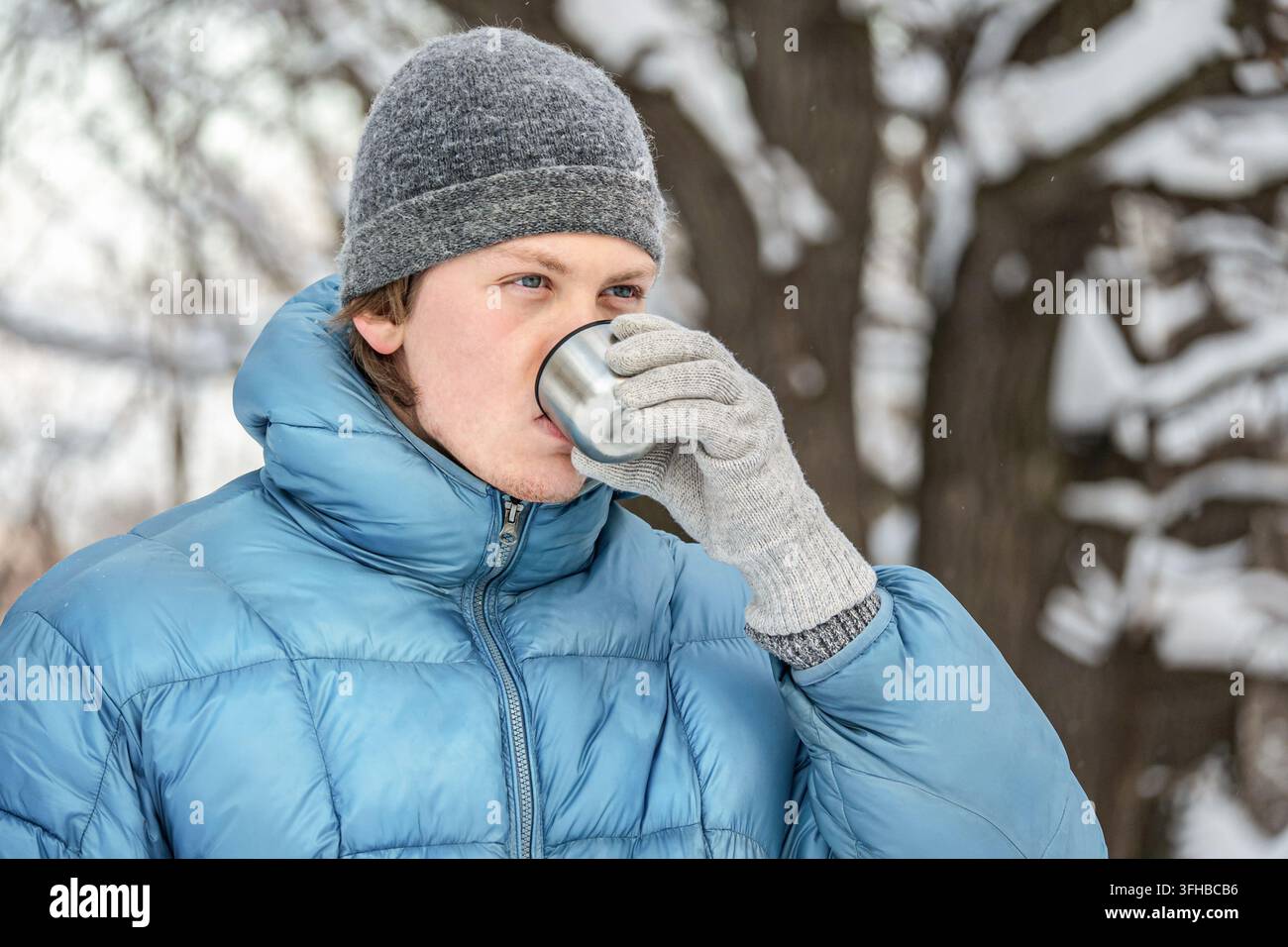 Uomo che beve una bevanda calda all'aperto durante l'inverno Foto Stock