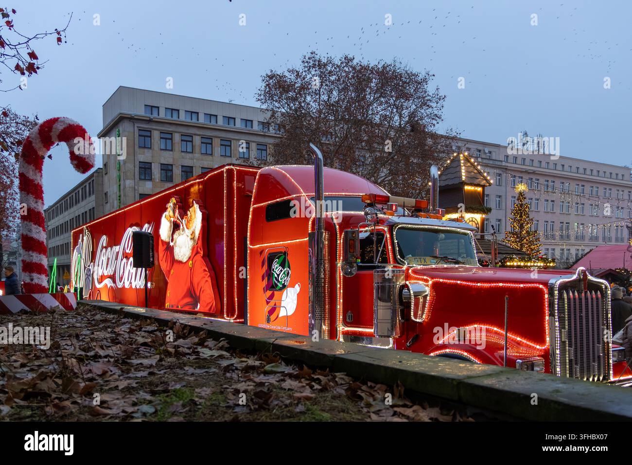 Poznań, Polonia - 13 dicembre 2025: Camion Coca-Cola decorato per il Natale con luminose luci artistiche, che crea un'atmosfera festosa in un'area pubblica Foto Stock