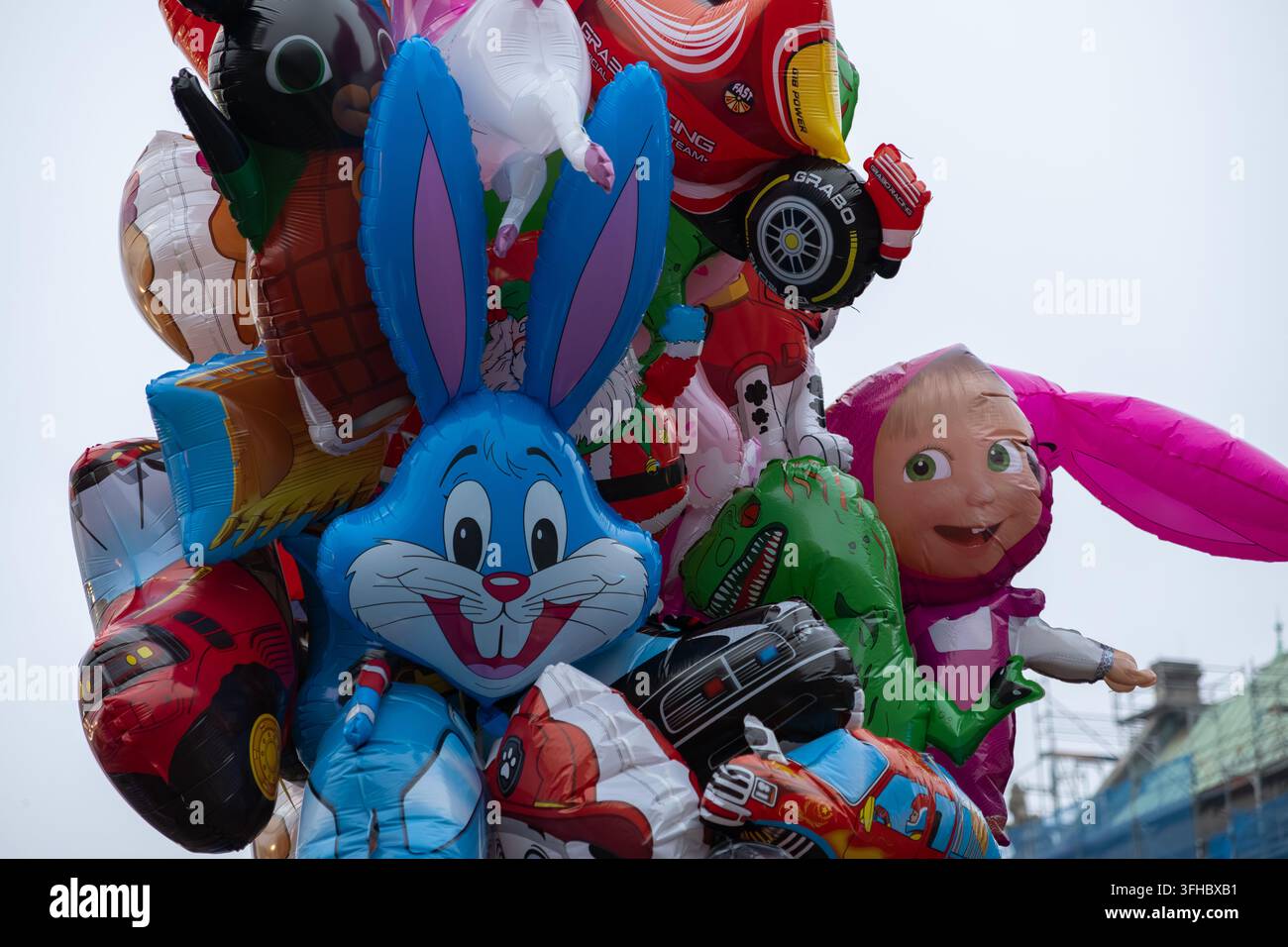 Pozna, Polonia – 13 dicembre 2025: Palloncini in lamina dai colori vivaci a forma di personaggi dei cartoni animati e veicoli riuniti per simboleggiare un'infanzia divertente Foto Stock