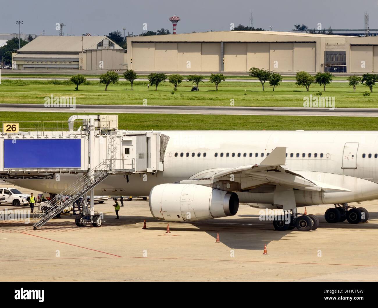 Aereo passeggeri commerciale parcheggiato al gate dell'aeroporto con ponte di imbarco Foto Stock