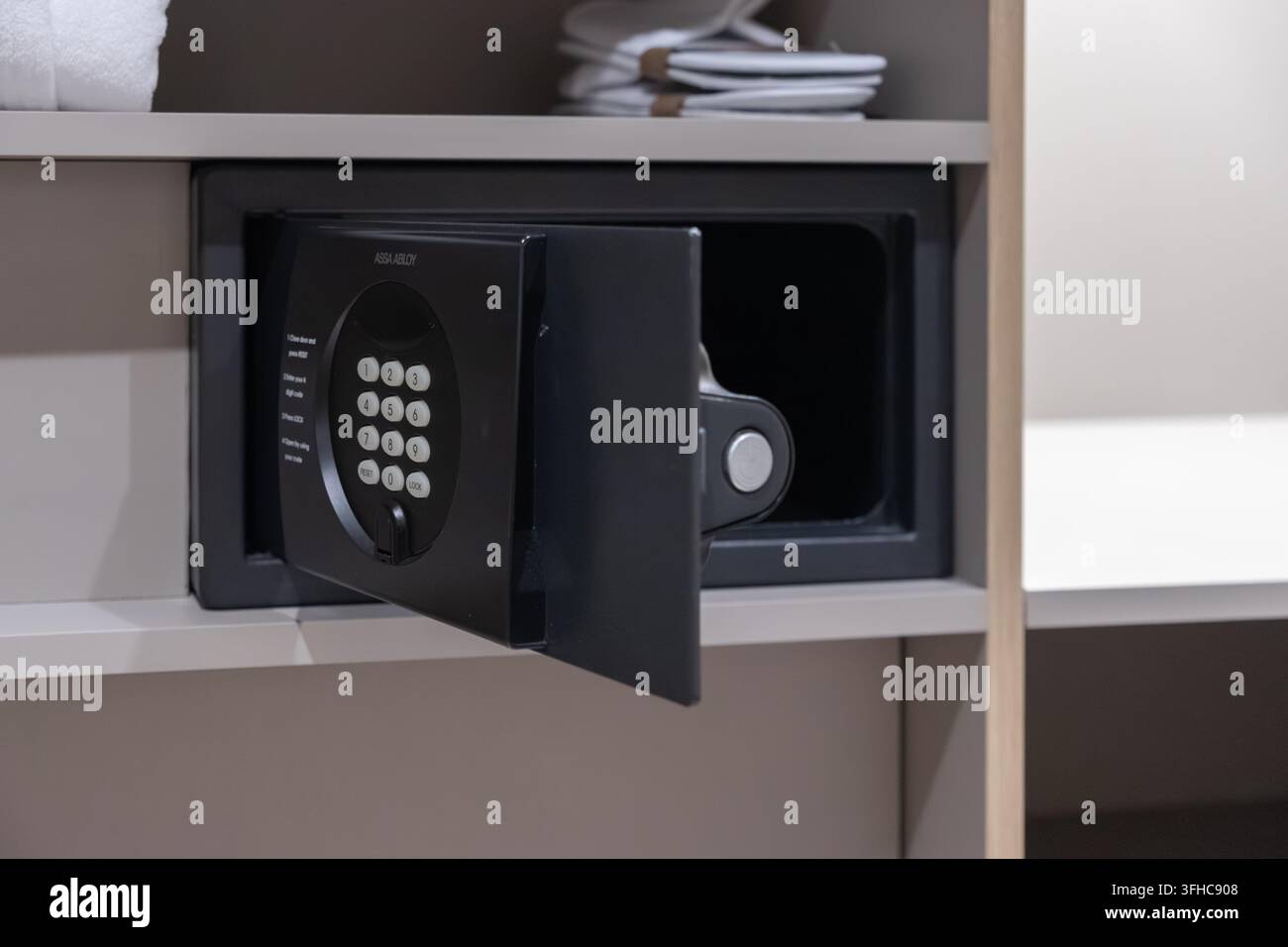 Szklarska Poręba, Polonia – 15 dicembre 2025: Cassaforte da parete in metallo Assa Abloy con tastierino digitale in un armadio aperto dell’hotel per garantire la sicurezza delle camere degli ospiti Foto Stock