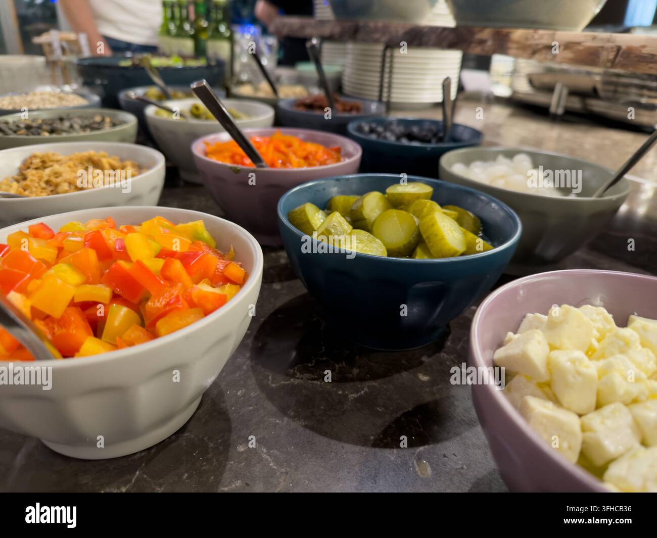 Prima vista di un buffet self-service con ingredienti freschi e vivaci, tra cui peperoni, sottaceti, formaggio feta, che promuove scelte alimentari sane Foto Stock