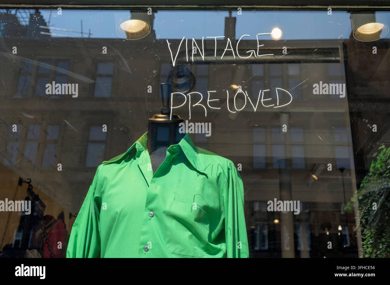 Camicetta verde vintage pre-amata di seconda mano in vendita nella vetrina di un negozio dell'usato, Regno Unito Foto Stock