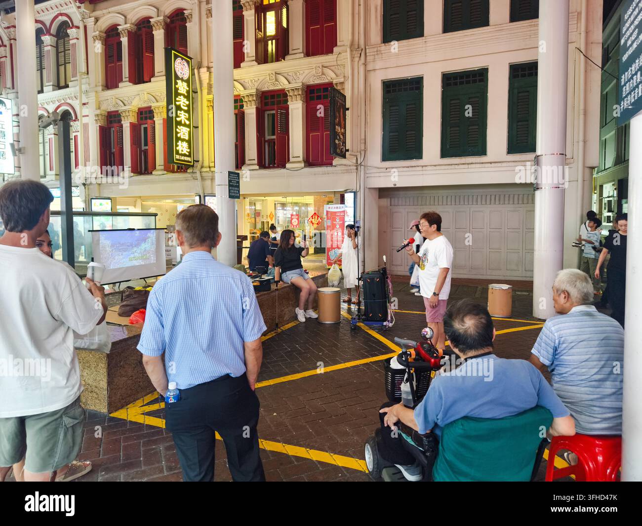 Performance pubblica di karaoke in un'area di ritrovo pubblica all'aperto nella strada Pagoda, Chinatown, Singapore Foto Stock