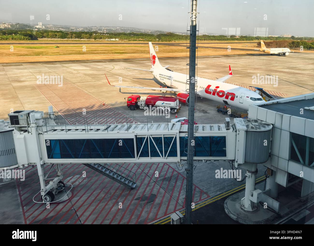 Aereo della Lion Air parcheggiato a un gate di imbarco collegato a una passerella di accesso alla pista dell'aeroporto di Changi, Singapore Foto Stock