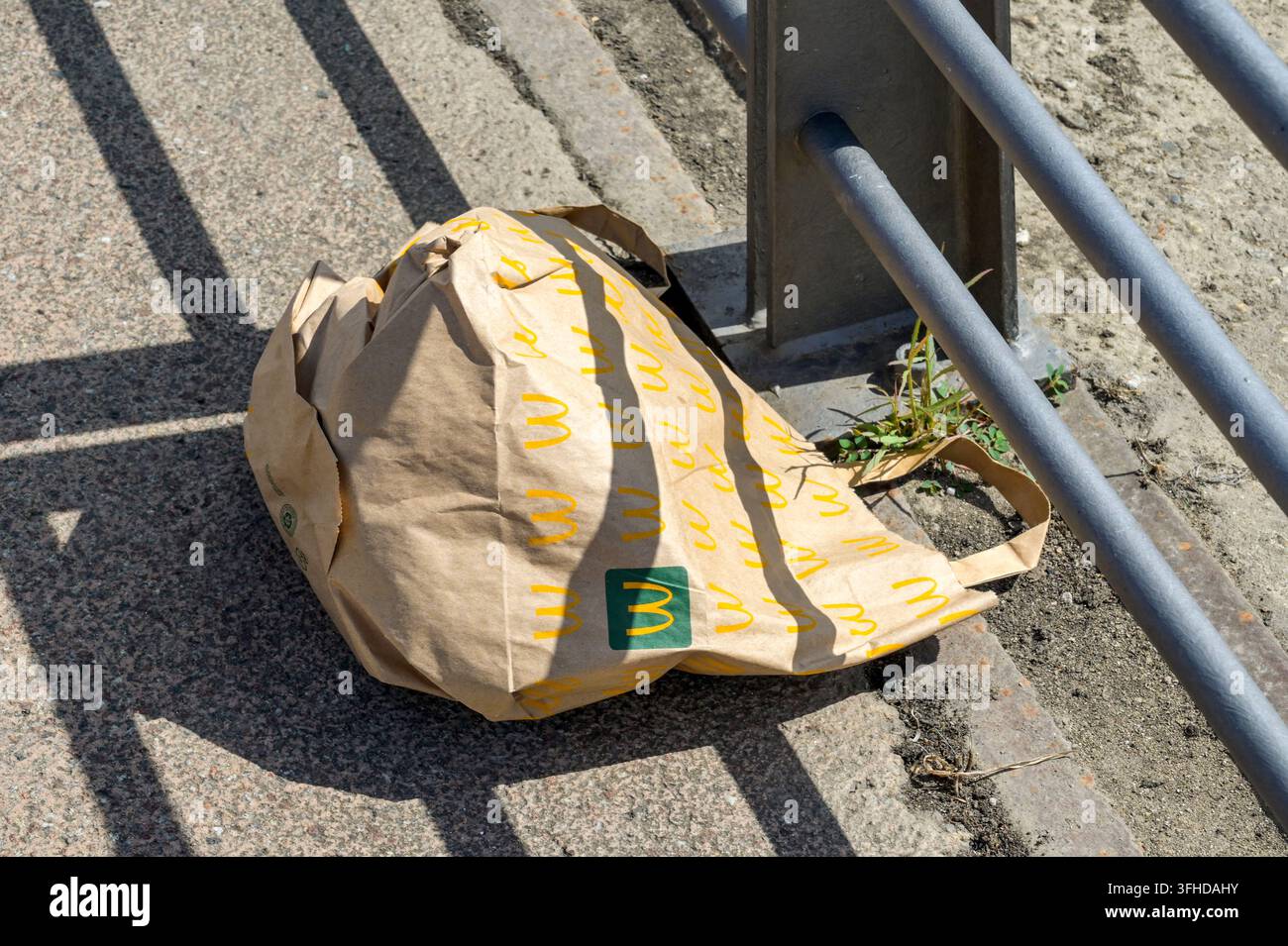 Bordeaux, Francia - 31 agosto 2026: Busta di carta marrone di un ristorante fast food McDonald's abbandonata sul terreno in una strada cittadina. Foto Stock