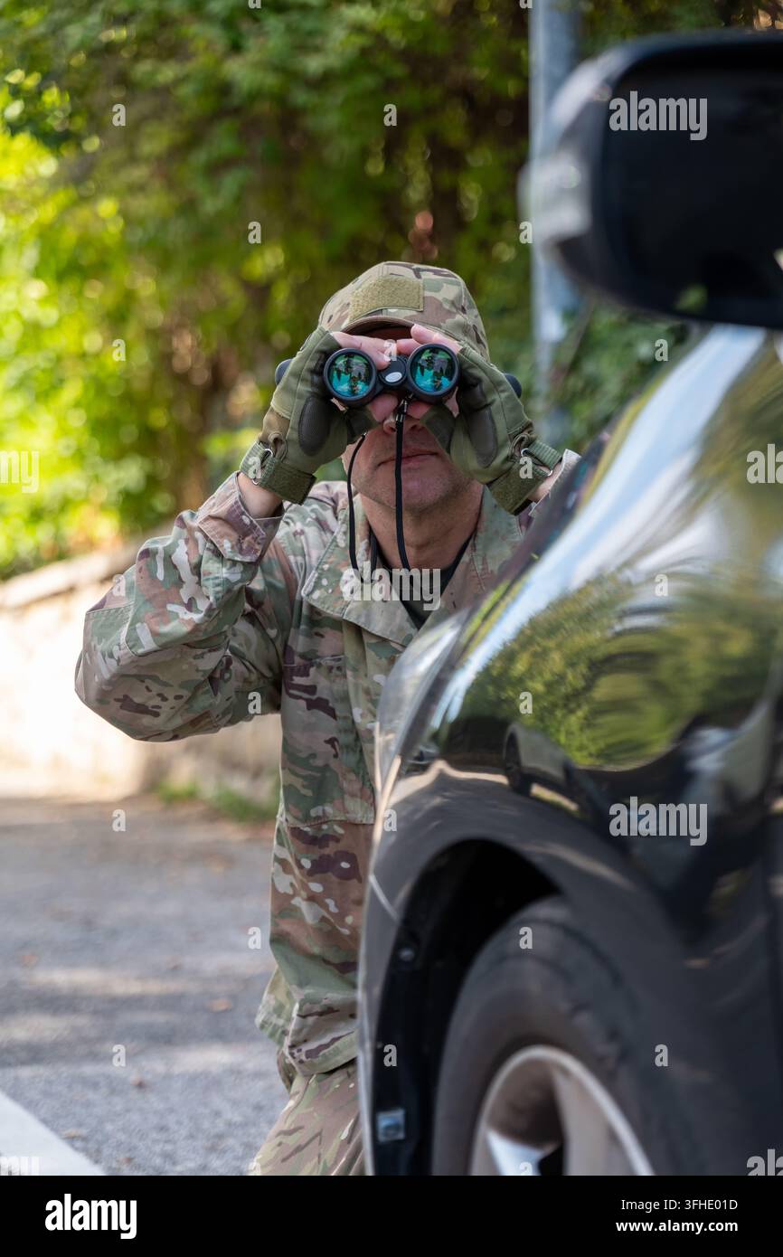 Agente militare conduce una sorveglianza segreta di un obiettivo utilizzando un veicolo come copertura per raccogliere informazioni Foto Stock