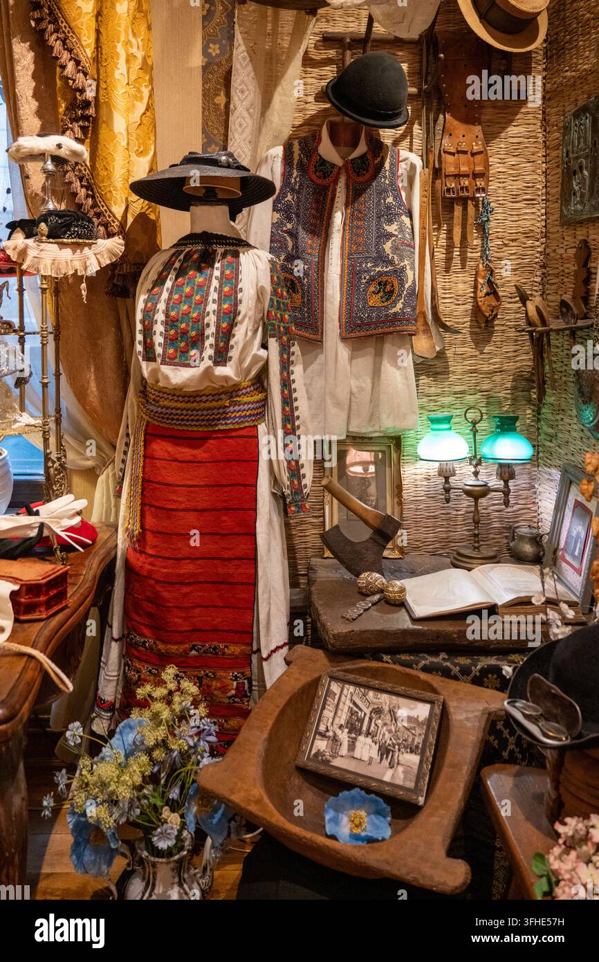 Bucarest, Romania - 4 nov 25: Costumi tradizionali rumeni, cappelli, tessuti e oggetti del patrimonio esposti al Piccolo Museo di Parigi a Bucarest. Foto Stock