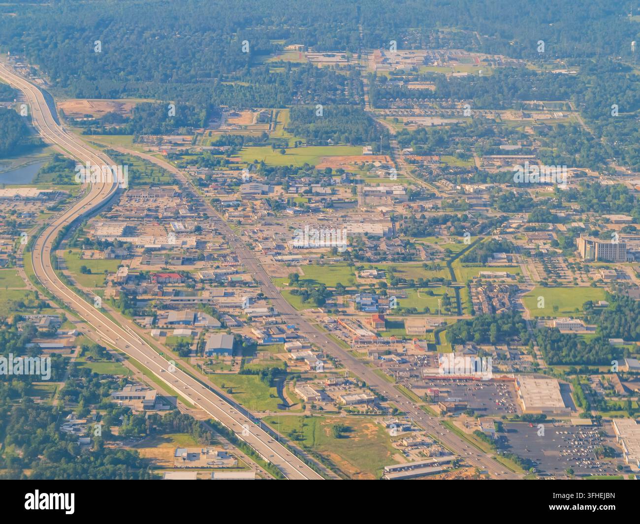 Autostrada che si snoda attraverso un paesaggio vasto di edifici industriali, parcheggi e spazi verdi in Oklahoma. Foto Stock