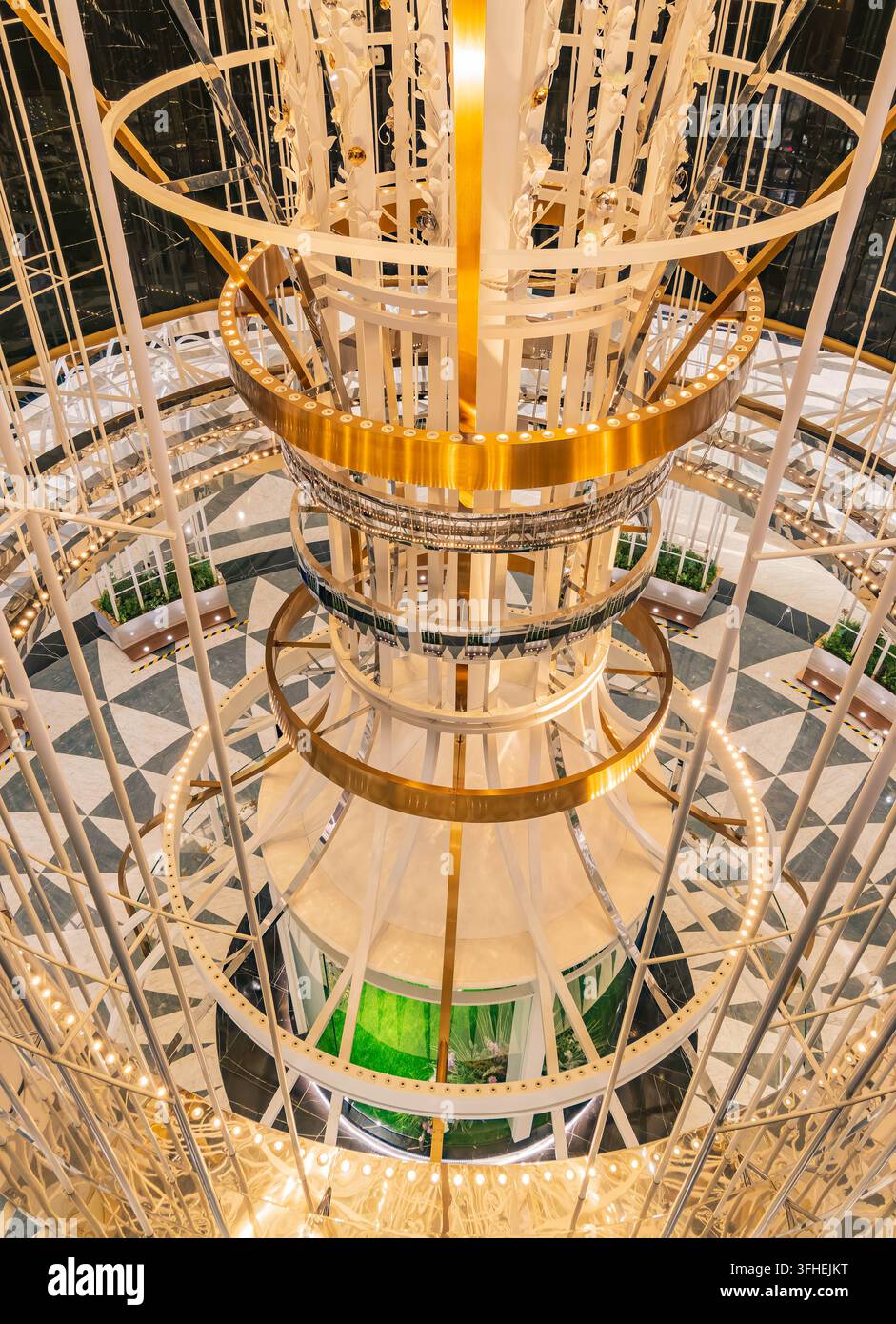 Diversi livelli di spirali dorate con luci incorporate creano un atrio decorativo all'interno. Foto Stock