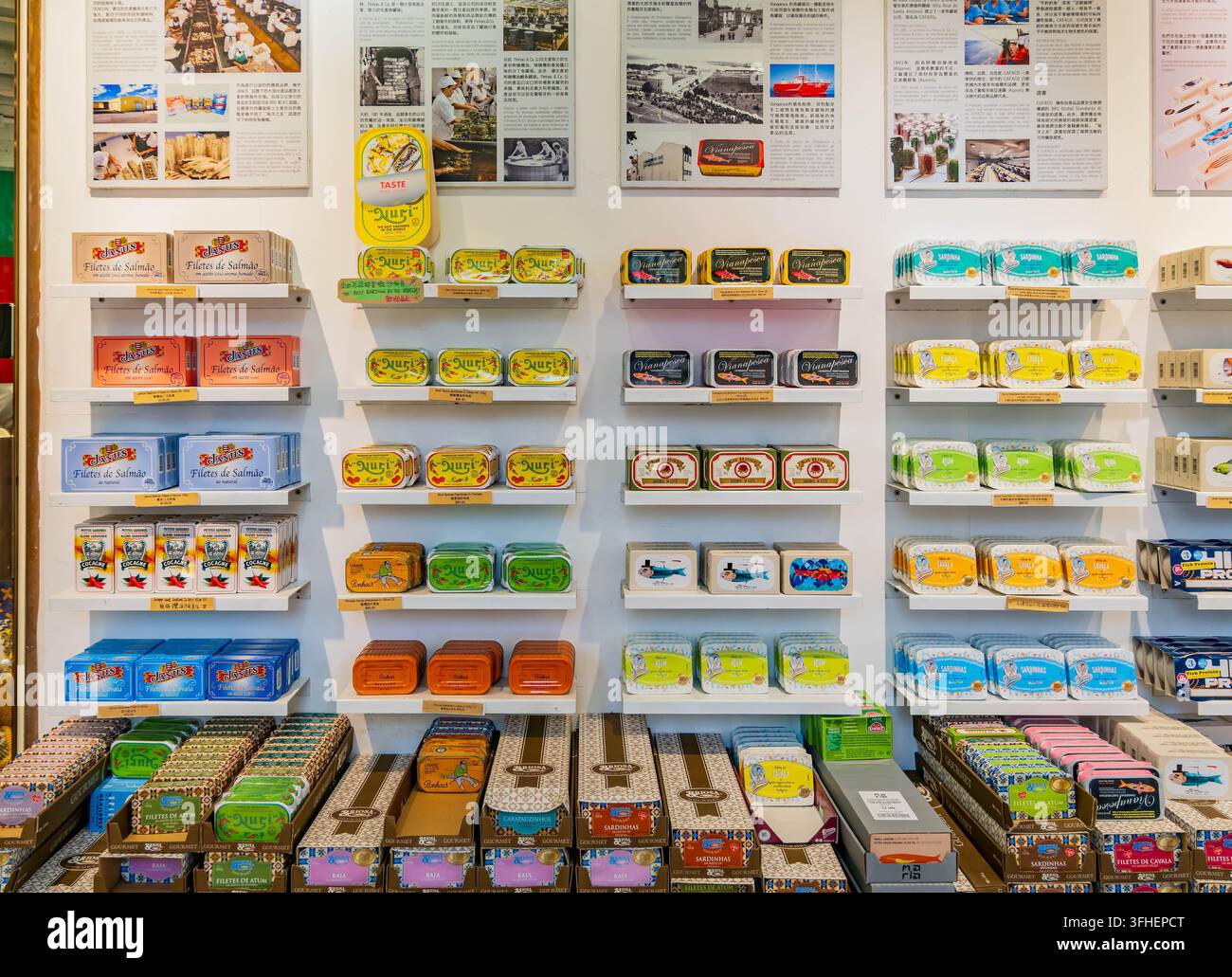 Macao, Cina, 17 apr. 2024 – Variate scatole rettangolari di latta e confezioni di cartone colorate riempiono più scaffali bianchi sullo sfondo di Foto Stock