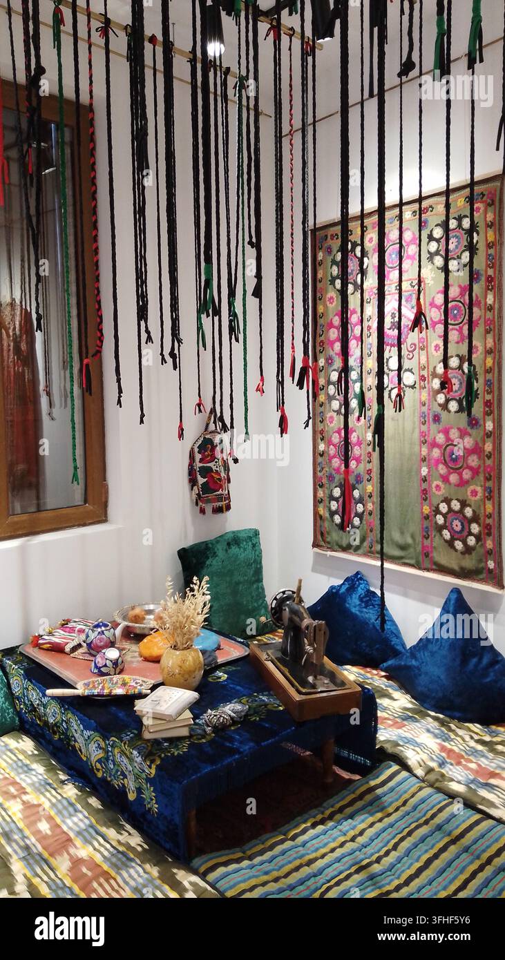 Tashkent, Uzbekistan - 18 aprile 2026 - Stanza culturale unica con borse fatte a mano, tessuti ricchi e colorati, macchina da cucire antica e decorazione folk creativa Foto Stock