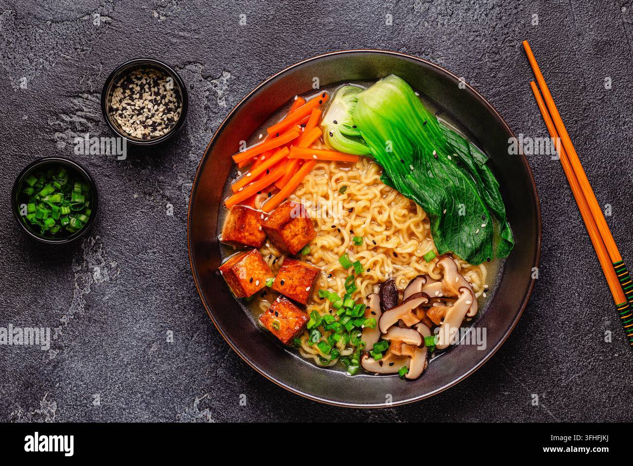 Zuppa miso ramen con noodles servita con tofu, bok choy, carote e funghi in una ciotola. Foto Stock