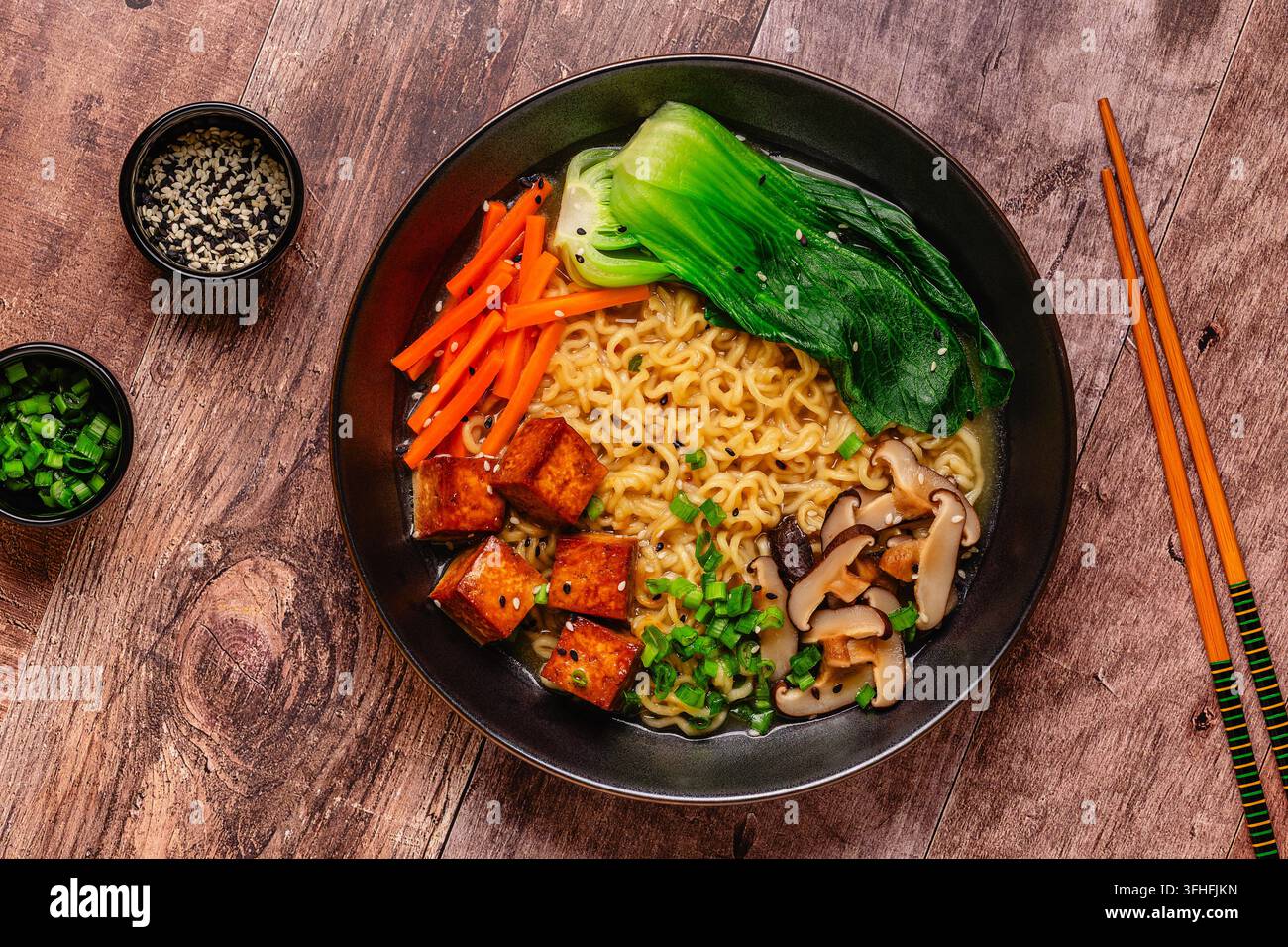 Zuppa miso ramen con noodles servita con tofu, bok choy, carote e funghi in una ciotola. Foto Stock