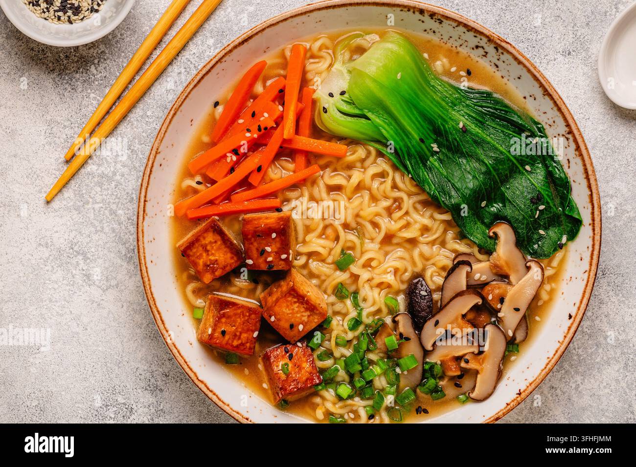 Zuppa miso ramen con noodles servita con tofu, bok choy, carote e funghi in una ciotola. Foto Stock