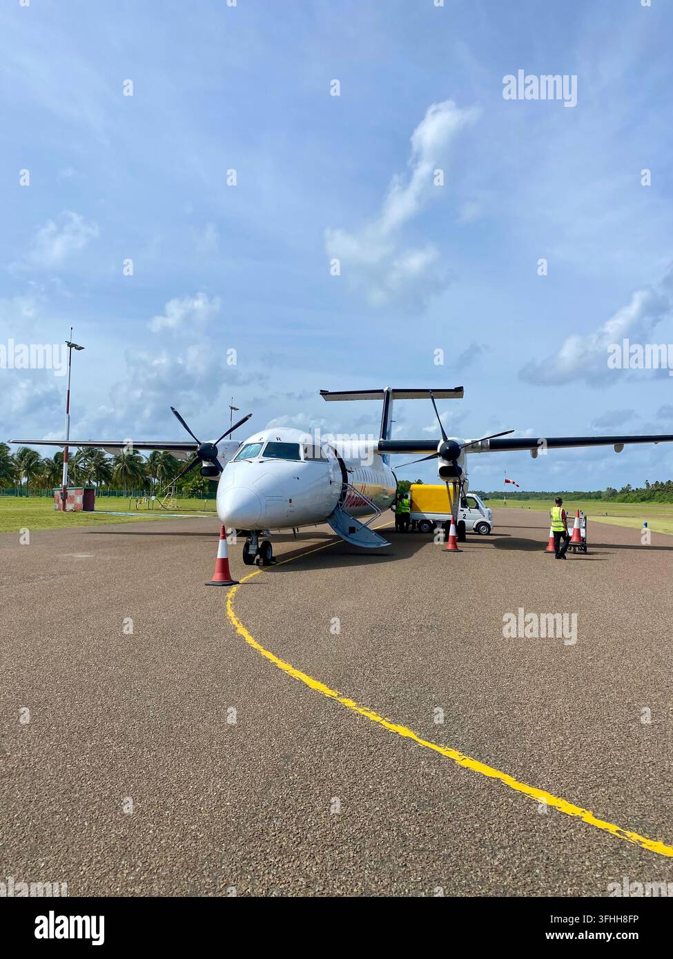 Maldive - 9 settembre 2022:     Aeroplano passeggeri turboalettone parcheggiato sulla pista di un aeroporto tropicale in pieno giorno. - Immagine stock catturata con smartphone