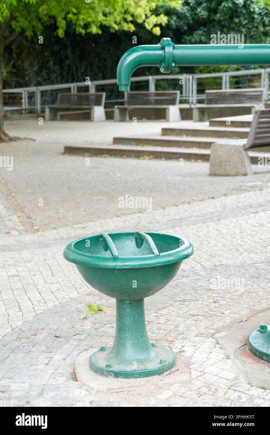 Colonna d'acqua sulla strada. Acqua potabile in città. Ciotola di metallo per l'acqua potabile Foto Stock
