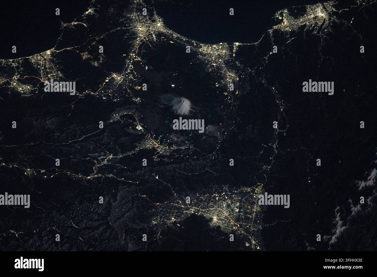 Il Monte Fuji è circondato dalle luci della città della regione dei Cinque Laghi di Fuji, 3 gennaio 2026 Foto Stock