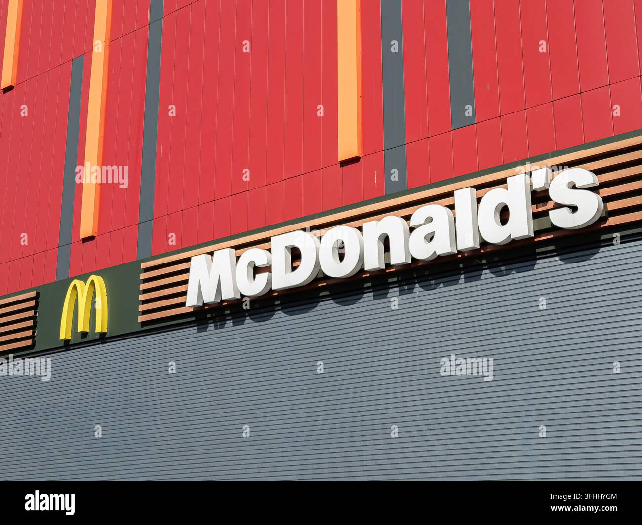 Kiev, Ucraina - 13 marzo 2026: Segnaletica esterna McDonald's esposta su un elegante muro di doghe grigie e pannelli rossi, che riflette un approccio contemporaneo Foto Stock