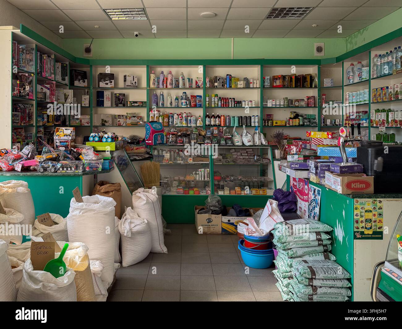 Horodok, Ucraina – 11 marzo 2026: Un interno di un negozio al dettaglio locale dove sacchi di cereali, articoli di consumo confezionati e varie selezioni di giocattoli creano Foto Stock
