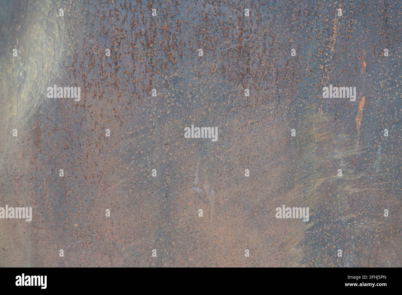 Superficie metallica arrugginita che mostra una texture consumata con varie sfumature di acciaio ossidato, creando uno sfondo astratto e grunge Foto Stock