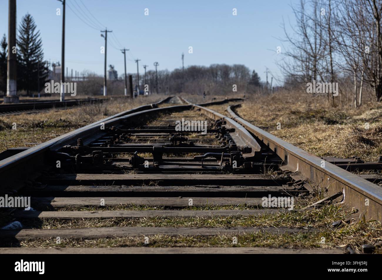 Le linee metalliche formano un incrocio in un ambiente rurale, evocando temi di trasporto, logistica, transizione, movimento, navigazione e la vasta espansione Foto Stock