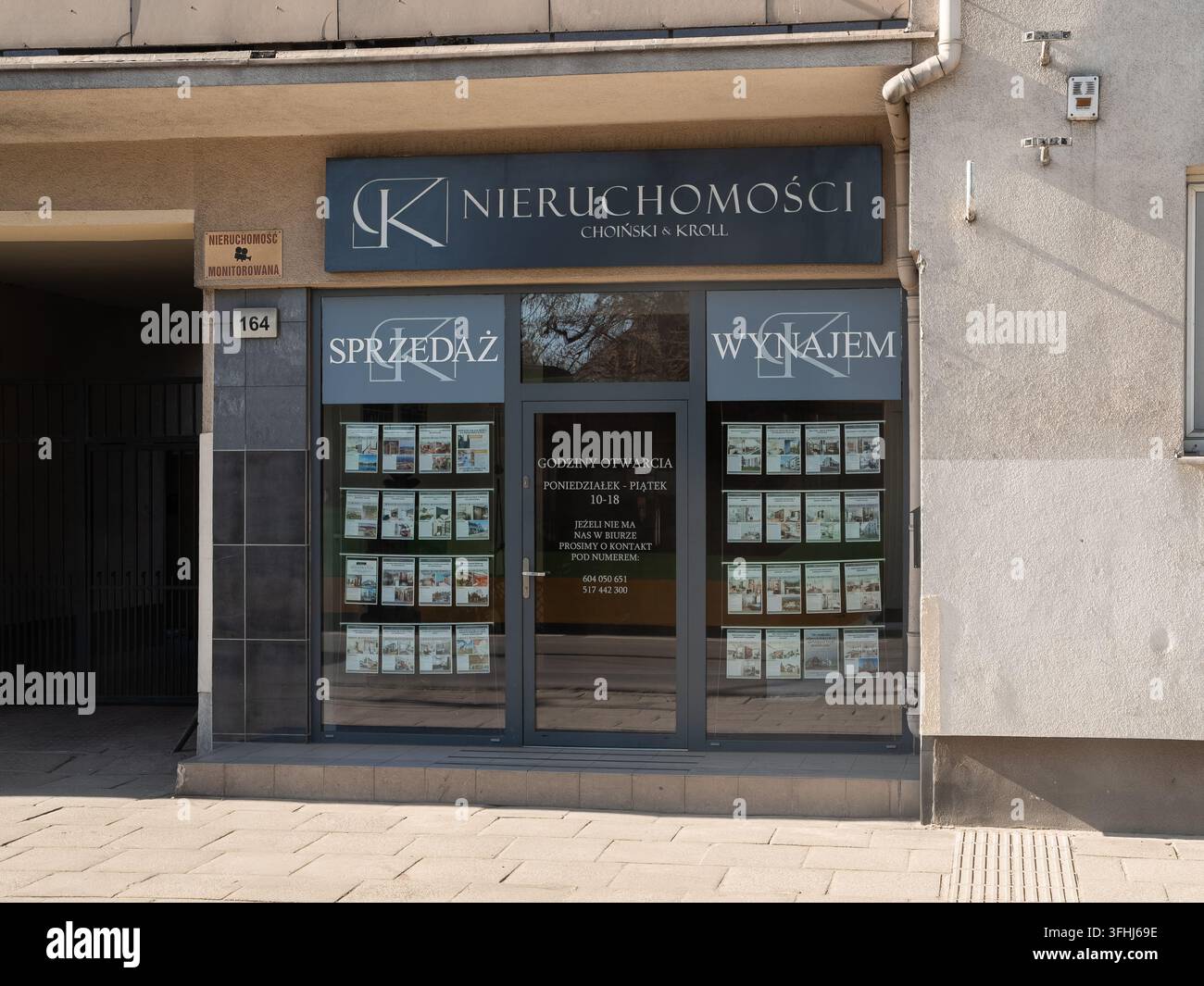 Poznań, Polonia – 6 marzo 2026: Esterno dell'ufficio di Choinski Kroll Nieruchomosci con cartelloni chiari e pubblicità di case nella vetrina per attrar Foto Stock
