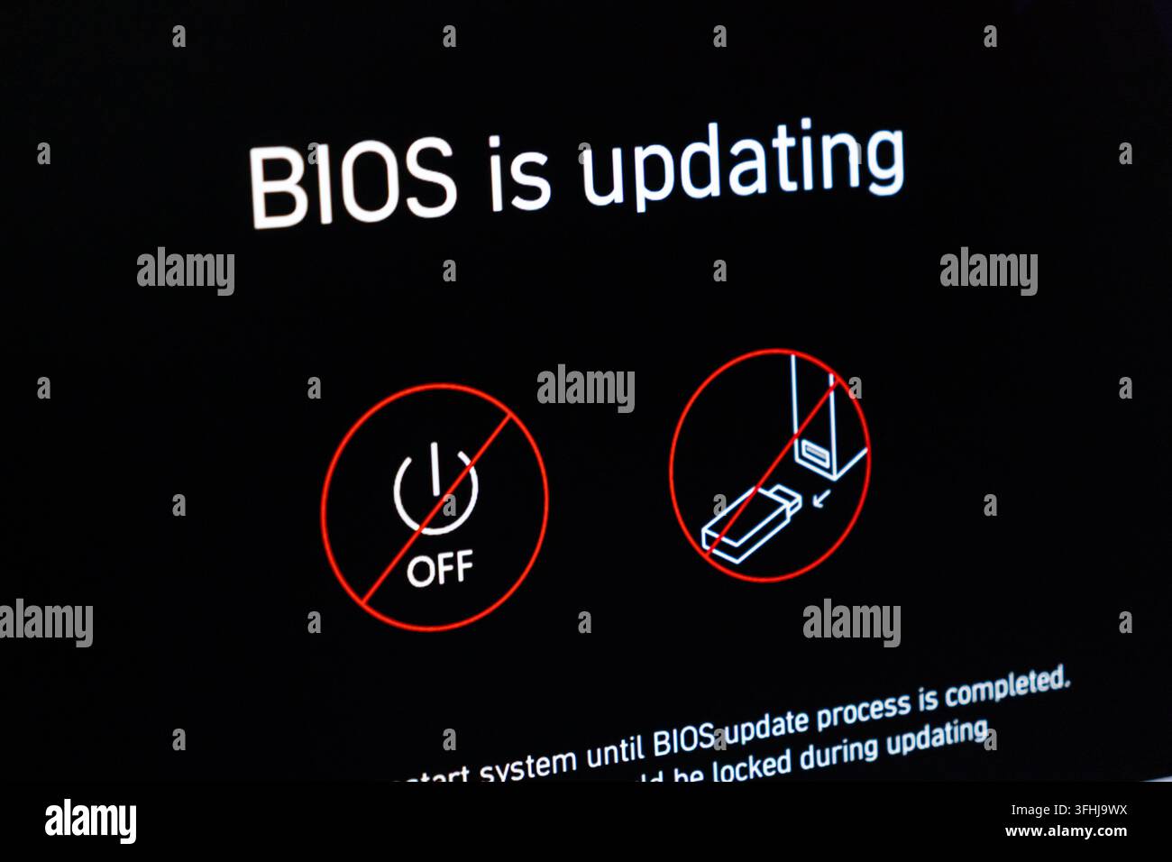 Poznań, Polonia – 15 febbraio 2026: Notifica di aggiornamento del firmware di sistema visualizzata su uno schermo nero per avvertire contro lo spegnimento della macchina durante l' Foto Stock