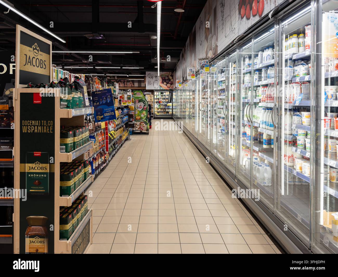 Pozna, Polonia – 16 gennaio 2026: gli scaffali del caffè Jacobs Retail si trovano in un negozio di alimentari accanto alle lunghe corsie refrigerate dei latticini per offrire una varietà di alimenti Foto Stock