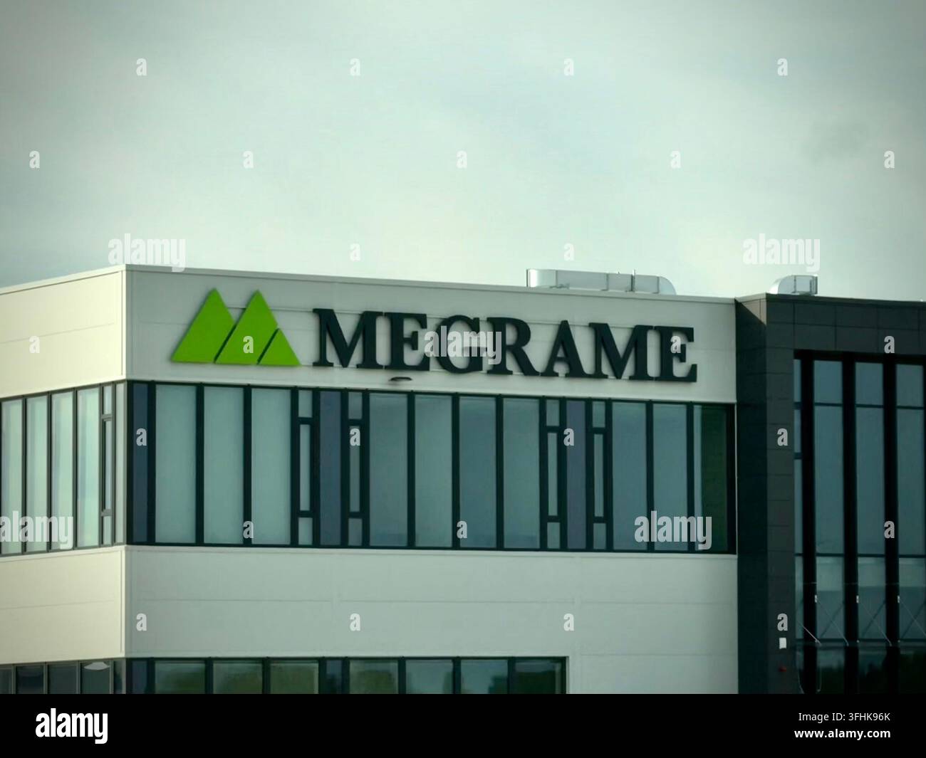 Primo piano esterno della linea del tetto della struttura MEGRAME in Lituania, con il logo aziendale verde e il testo del logo Foto Stock