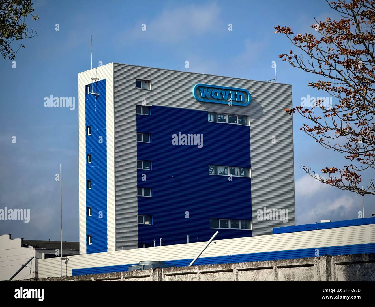 Facciata moderna di un edificio industriale di Wavin in Lituania, produttore di tubi in plastica e sistemi di gestione dell'acqua. Presenta metallo blu e grigio - Immagine stock catturata con smartphone