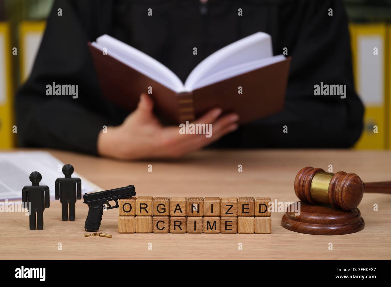 Scena di tribunale con figurini e tema di criminalità organizzata che suscita una seria discussione sulla giustizia Foto Stock