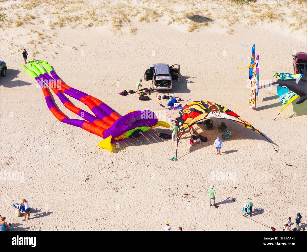 Vista aerea di un festival di aquiloni con grandi aquiloni a forma di polpo e farfalla sulla spiaggia sabbiosa con persone radunate a Kure Beach, North Carolina Foto Stock
