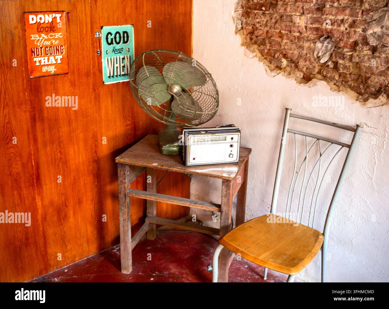 Titolo Angolo vintage con ventilatore retrò, radio a transistor e muro di mattoni a vista Foto Stock