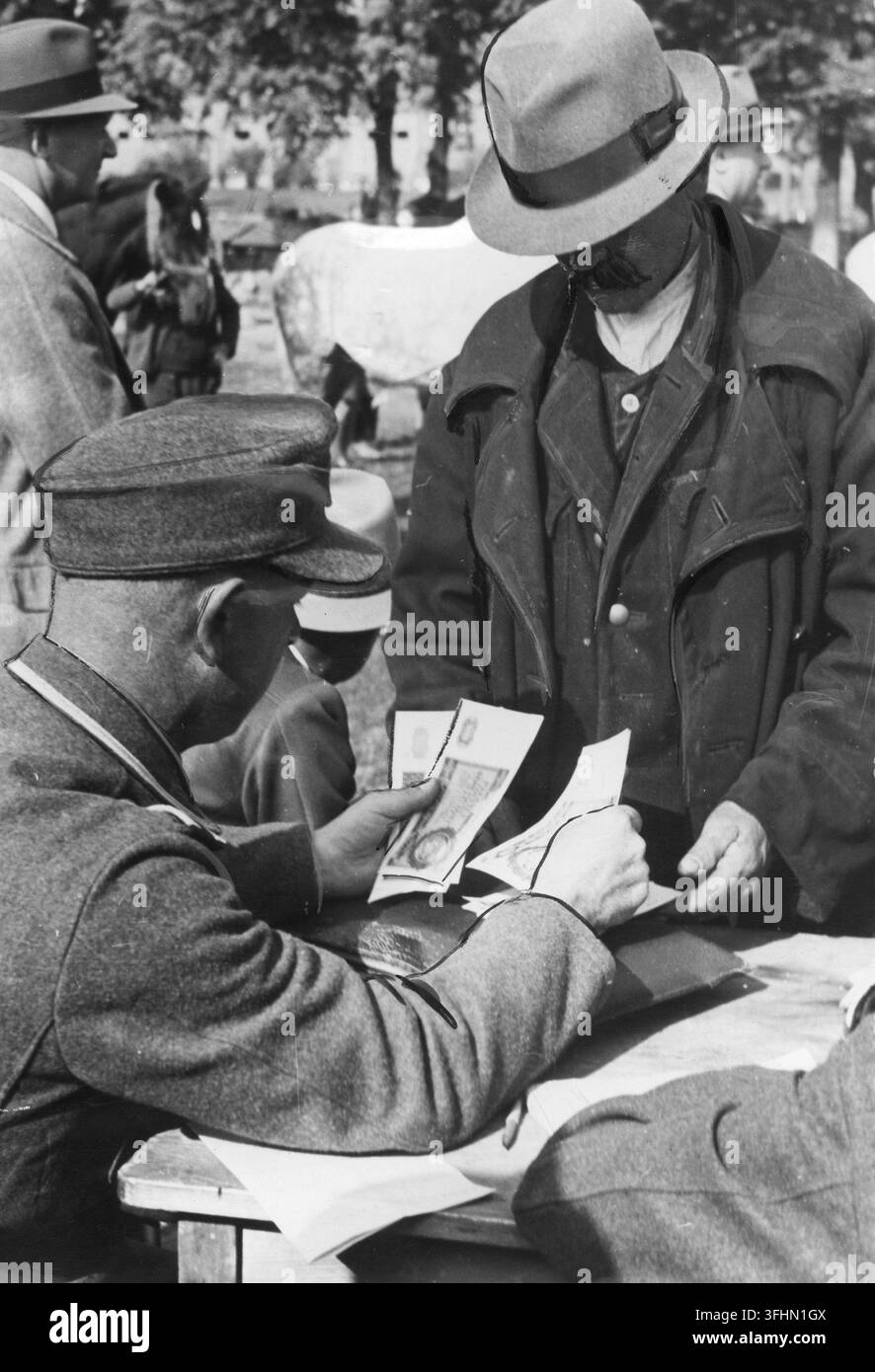 Un soldato tedesco paga un allevatore di cavalli per i cavalli, ottobre 1943. Foto Stock