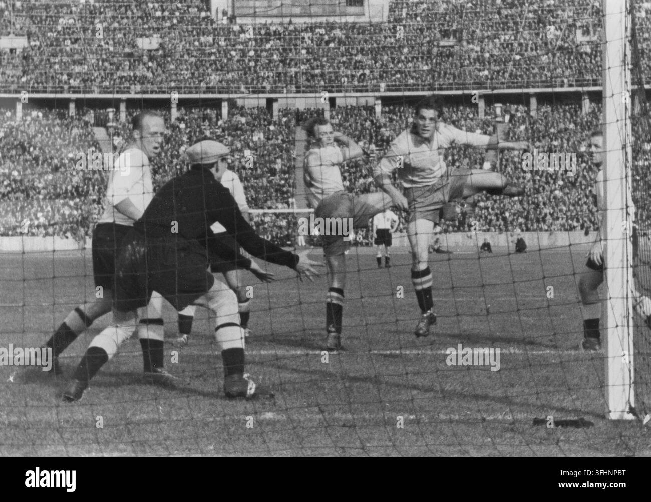I calciatori svedesi Gren e Nyberg attaccano la porta, mentre il portiere tedesco Helmut Jahn afferra la palla, 20 settembre 1942. Foto Stock