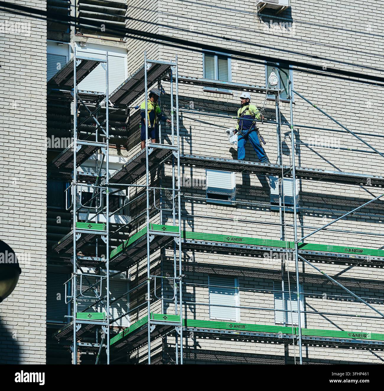 Operai edili che lavorano su una struttura di ponteggio metallica in un edificio residenziale a Leganés, Madrid, Spagna Foto Stock