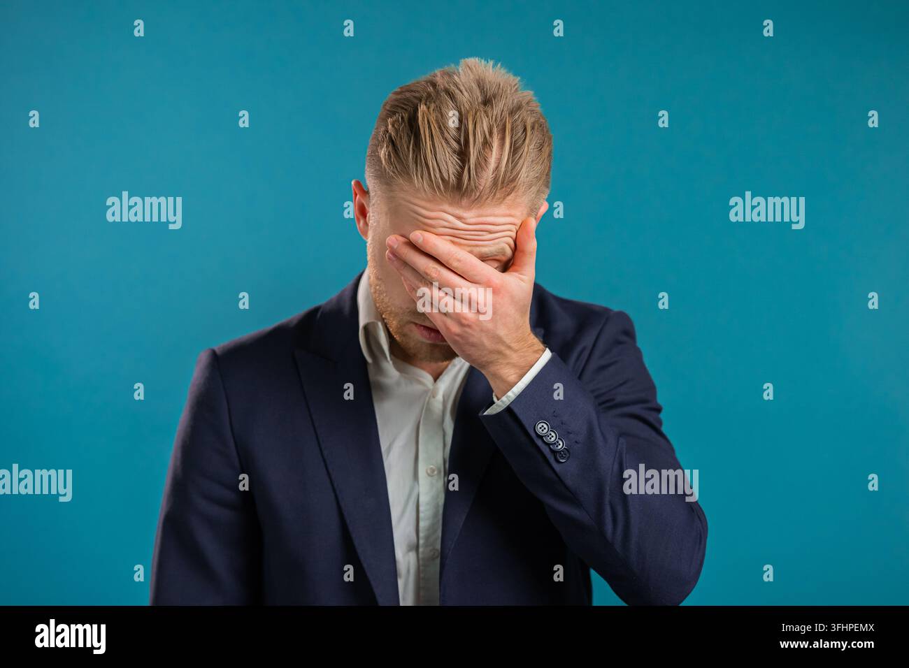 Ritratto di un uomo d'affari che fa il gesto del facepalm, come a dire no, ho dimenticato. Uomo infelice che prova dolore, rimpianto, dramma, fallimento. Si isola Foto Stock