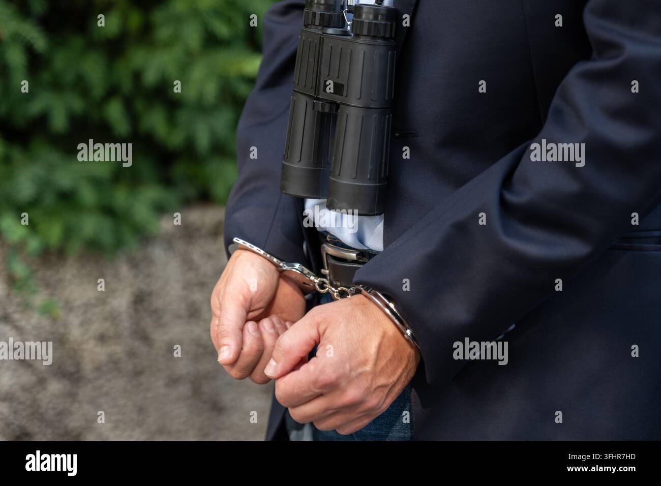 Le manette rappresentano le possibili conseguenze legali del tracciamento illegale, dello stalking e della raccolta non autorizzata di informazioni personali Foto Stock