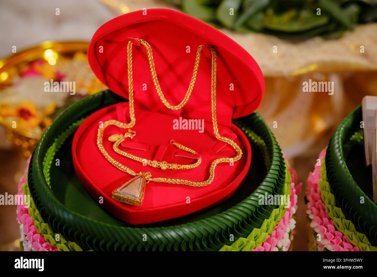 Elegante set di gioielli con collana d'oro all'interno di una scatola a forma di cuore rossa per il fidanzamento matrimoniale Foto Stock