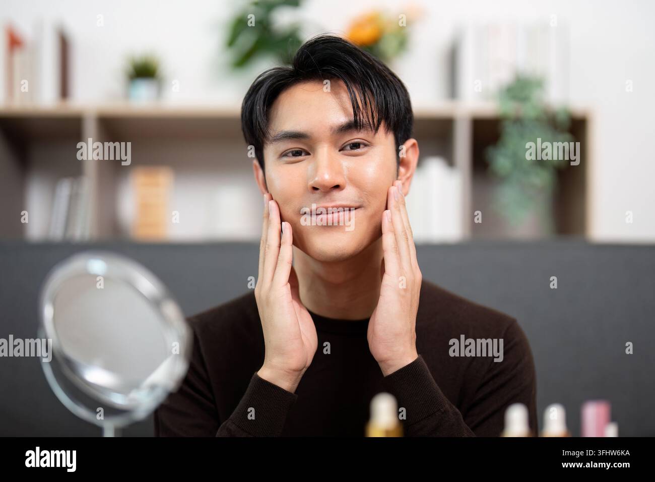 Cura di sé. Uomo sorridente dopo aver applicato prodotti per la cura della pelle a casa. Foto Stock