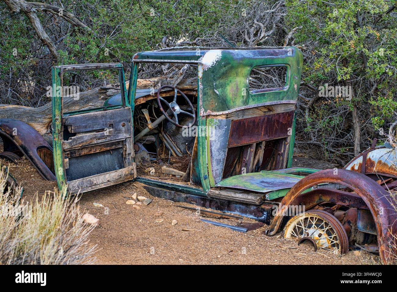 I resti arrugginiti di un veicolo d'epoca degli anni '30, trasformato da auto a camion, si trovano vicino al sentiero Wall Street Mill nel Parco Nazionale di Joshua Tree, California Foto Stock