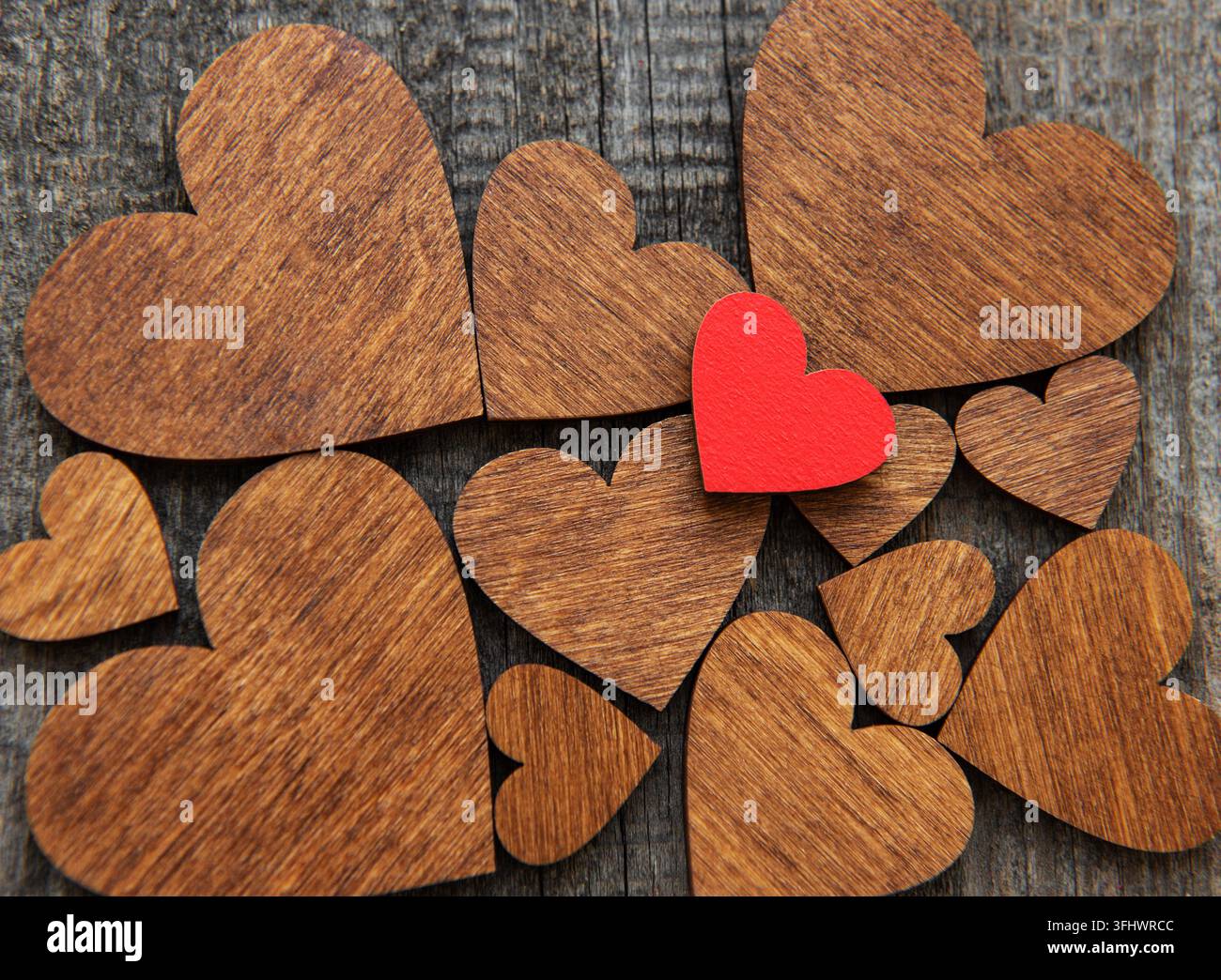 Cuore di legno rosso su uno sfondo a forma di cuore in legno Foto Stock