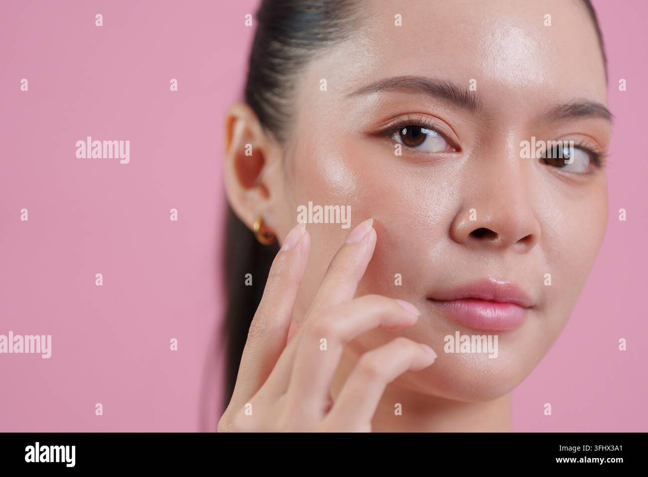 Donna asiatica che tocca il viso liscio per il concetto di bellezza e routine di cura della pelle Foto Stock